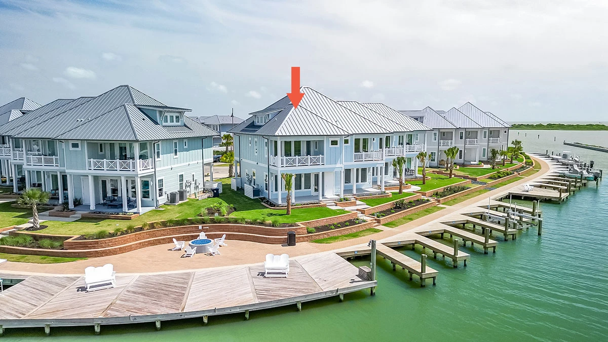 Coastal waterfront townhomes with boat slips and a red arrow highlighting one unit.